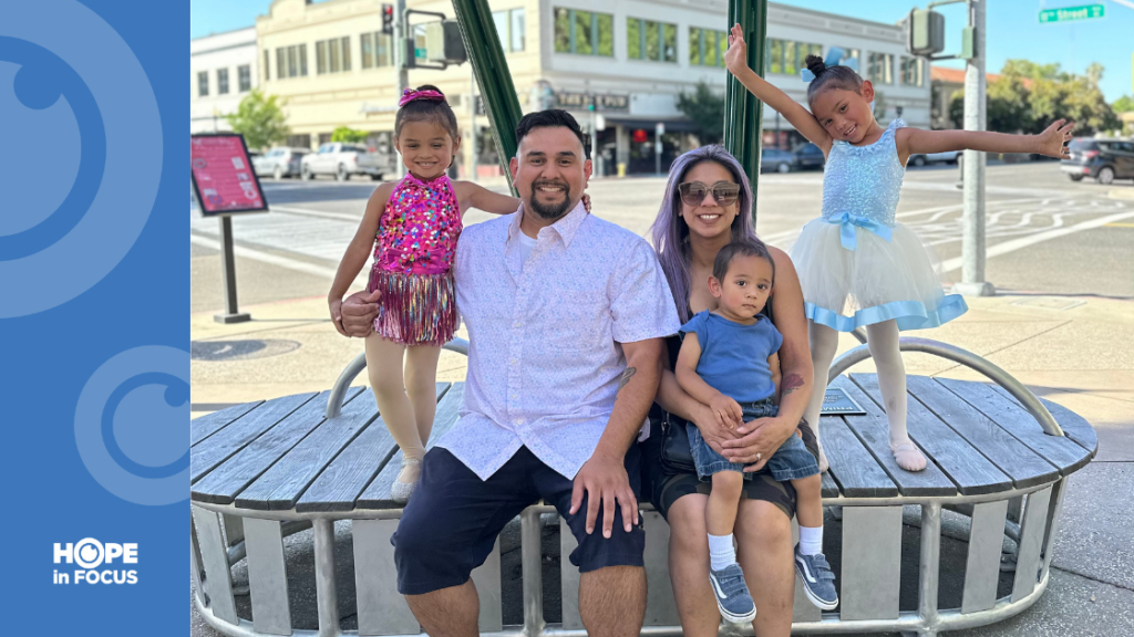 Christine and Anthony Gonzales sitting on a circular outdoor bench with their children Iliana, Malaya, and Amari Gonzales