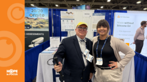 Eric Hartman and Courtney Coates standing together at an exhibition booth during a retinal research conference