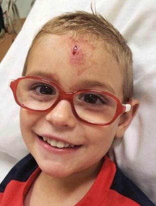 Elliot Wolf smiling while wearing red glasses